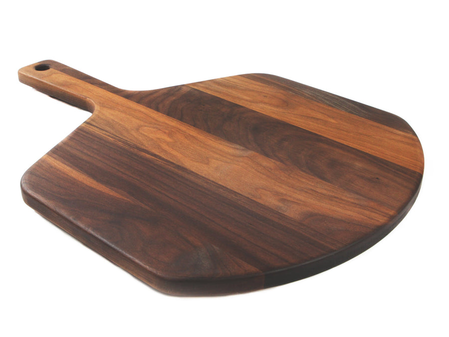 Walnut pizza peel shown at an angle with its handle extending to the left
