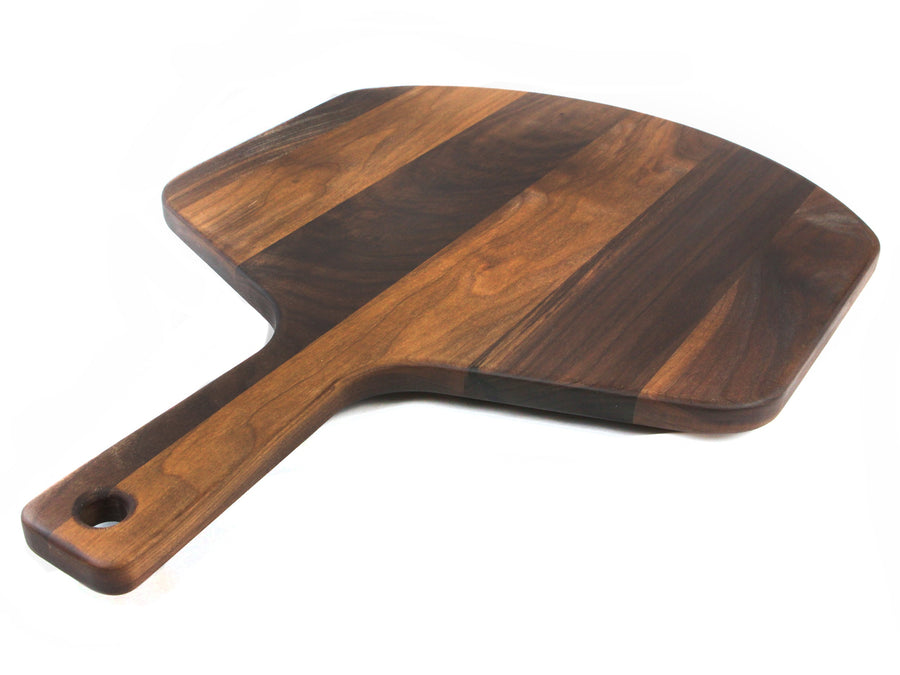 Walnut pizza peel photographed at an angle on a white background