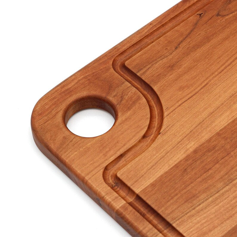 Walnut pizza peel photographed at an angle on a white background