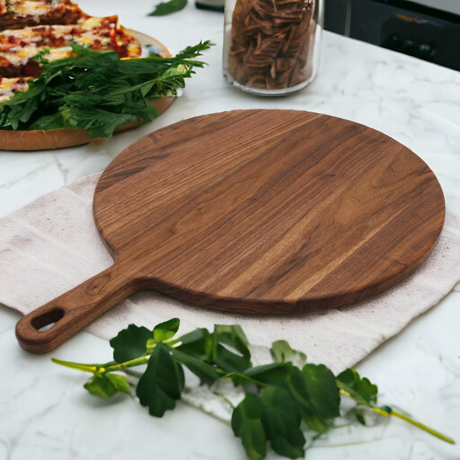 Baked pizza being carried on a wooden pizza peel