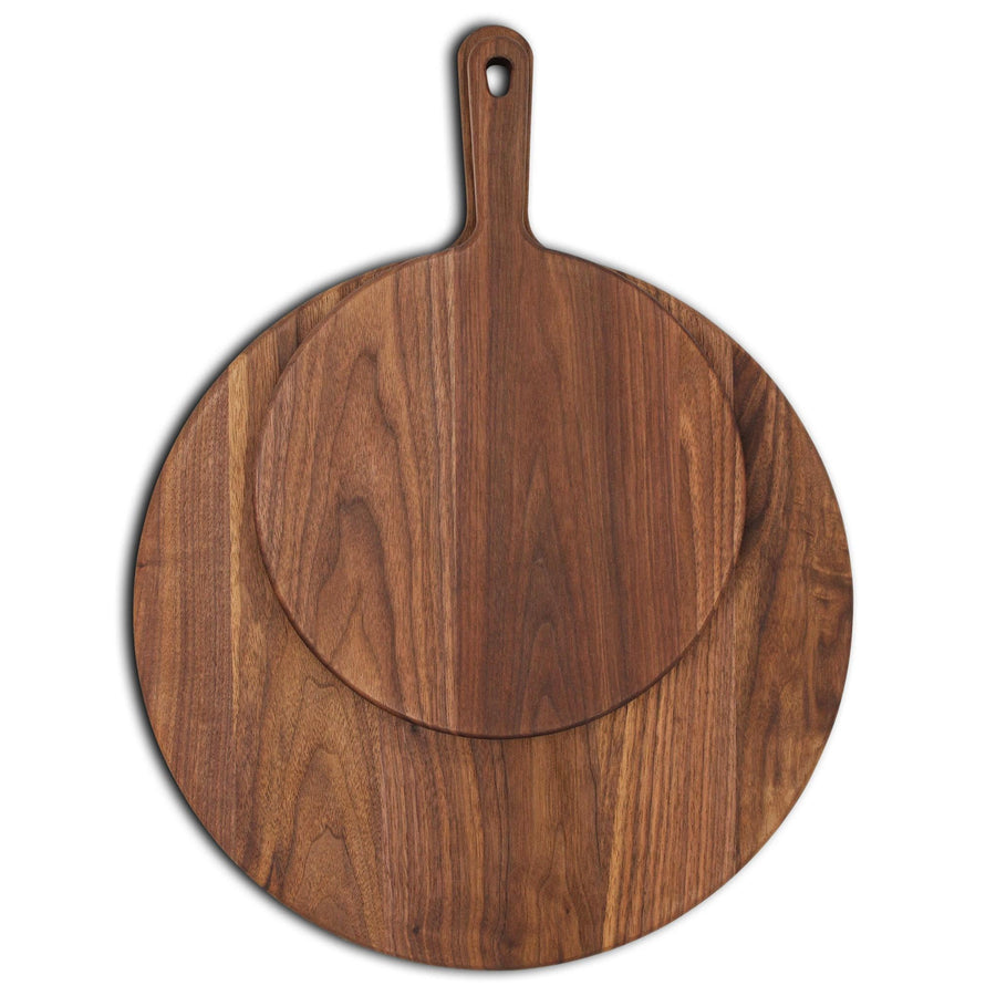 Two round walnut paddle boards stacked to compare their circular surfaces