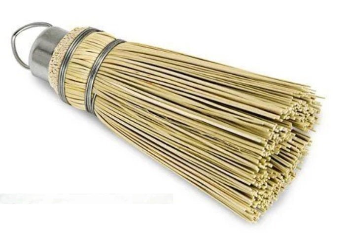 Small broomcorn cake tester lying on its side with a metal hanging loop