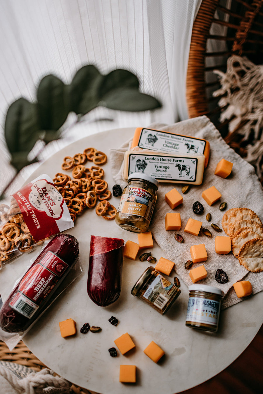 Overhead serving arrangement of wrapped sausage, cheese, pretzels and mustard