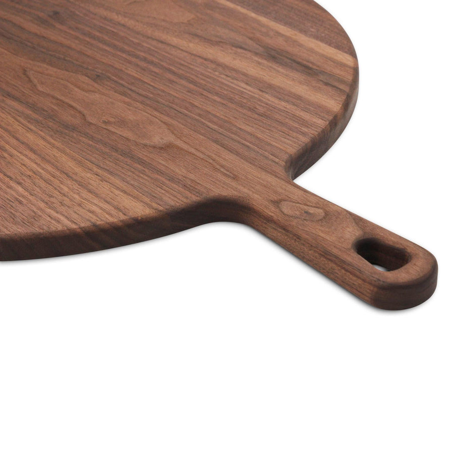 Close view of a round walnut paddle's handle and hanging hole