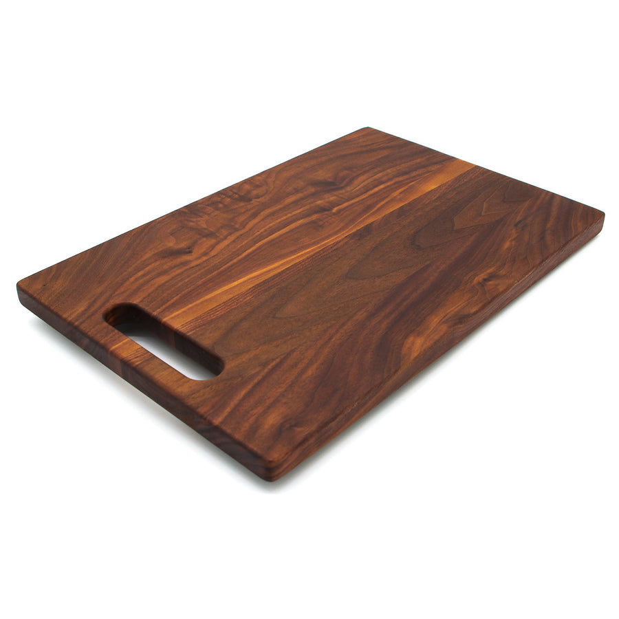 Walnut cutting board with a single cutout handle, angled view