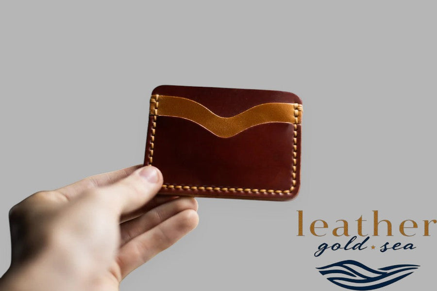 Hand holding two-tone brown leather card holder
