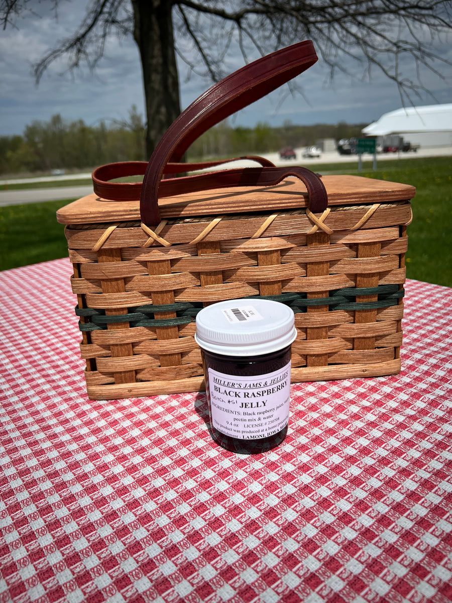 Miller’s Black Raspberry Jelly 9.4 oz jar beside a picnic basket.