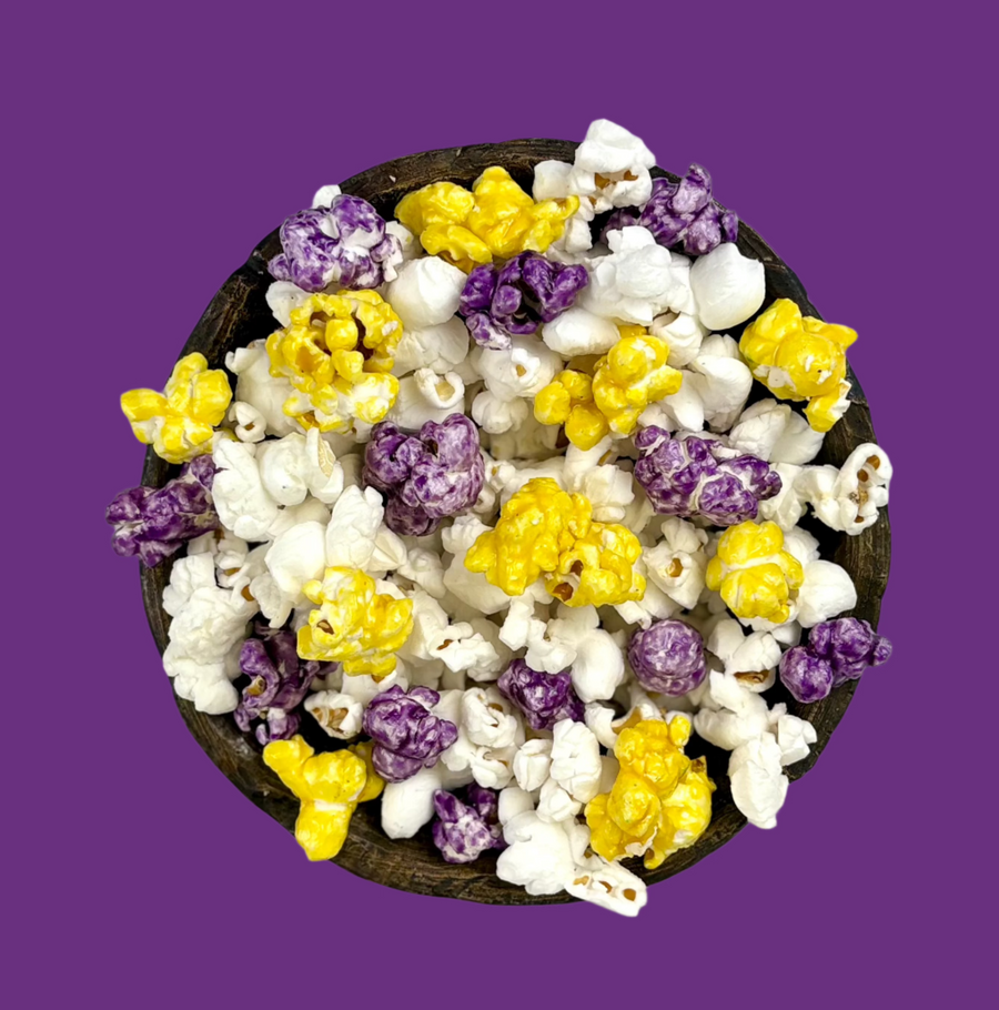 Bowl of purple & yellow candy-coated and white salted popcorn