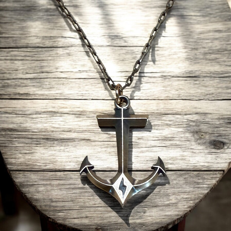 Hold Fast Anchor necklace against pale wood