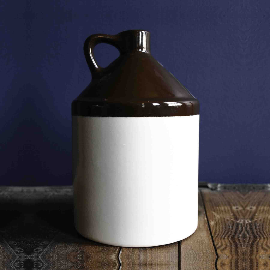Stoneware Beverage Jug - 1 Gallon with a dark shoulder and light lower body on a wood surface