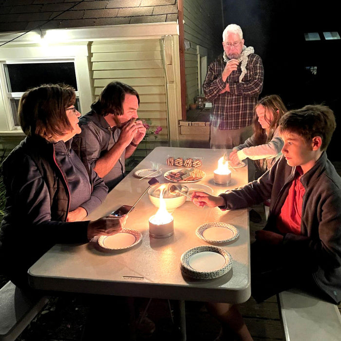 Family enjoying a s’mores gathering around a table