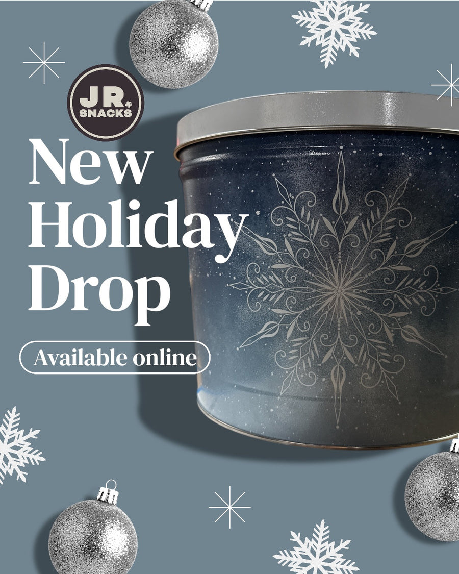 Holiday popcorn tin with a blue seasonal design and New Holiday Drop text
