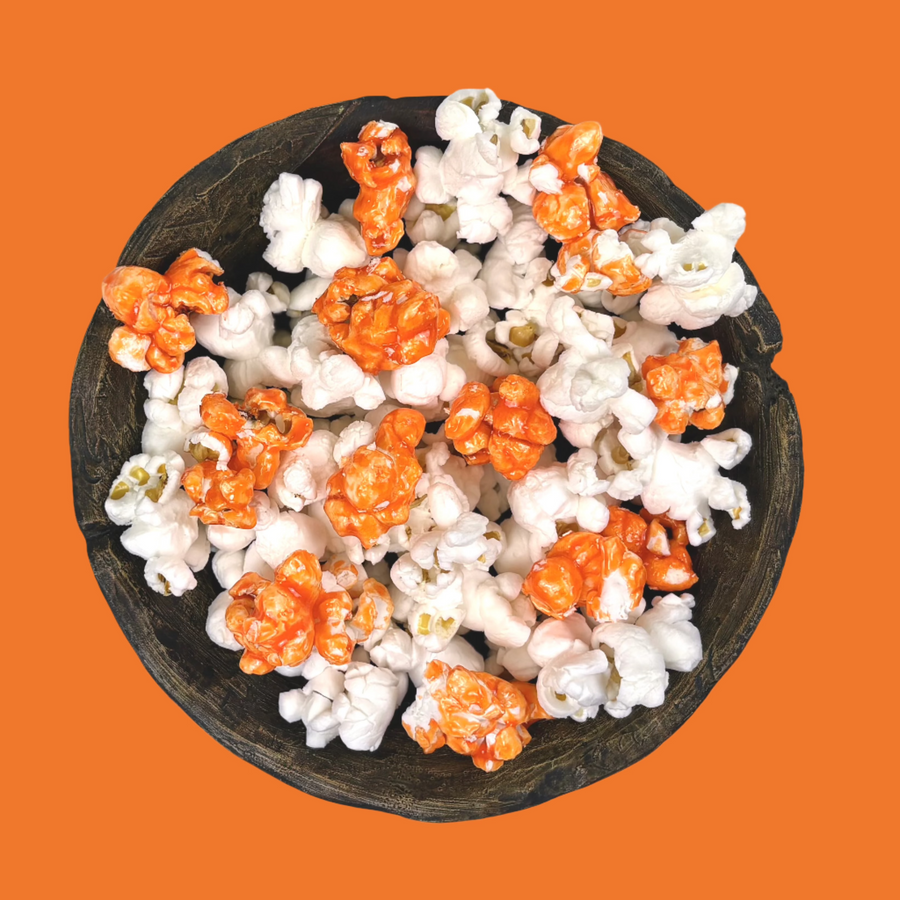 Bowl of orange candy-coated and white salted popcorn