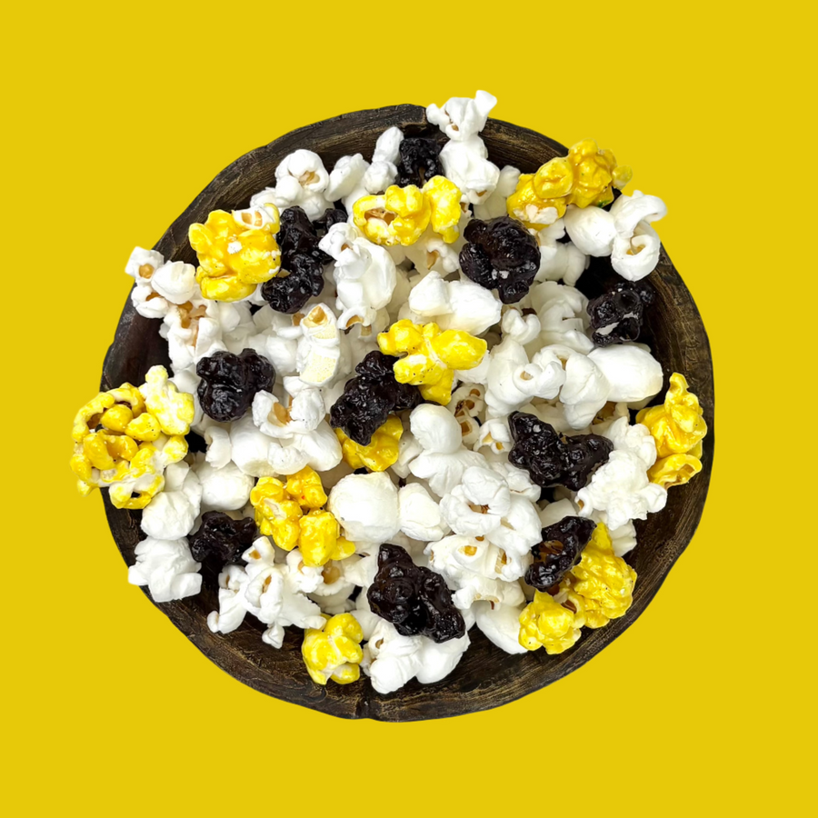 Bowl of black & yellow candy-coated and white salted popcorn