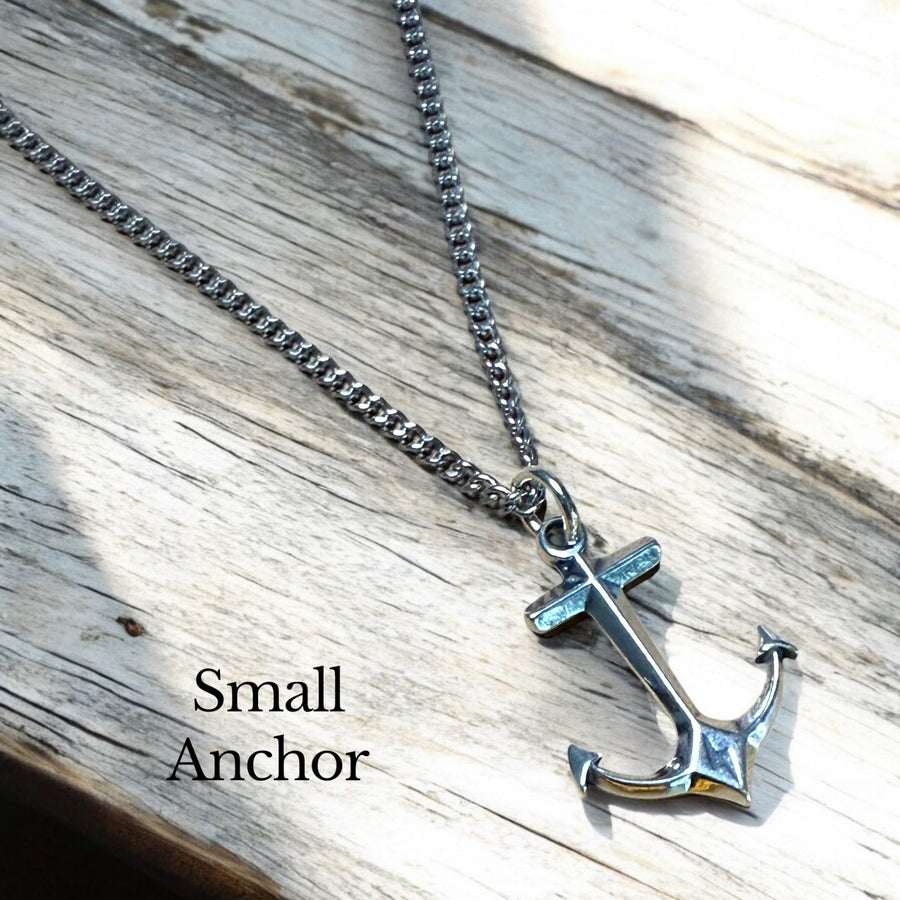 Small anchor pendant on chain against wood