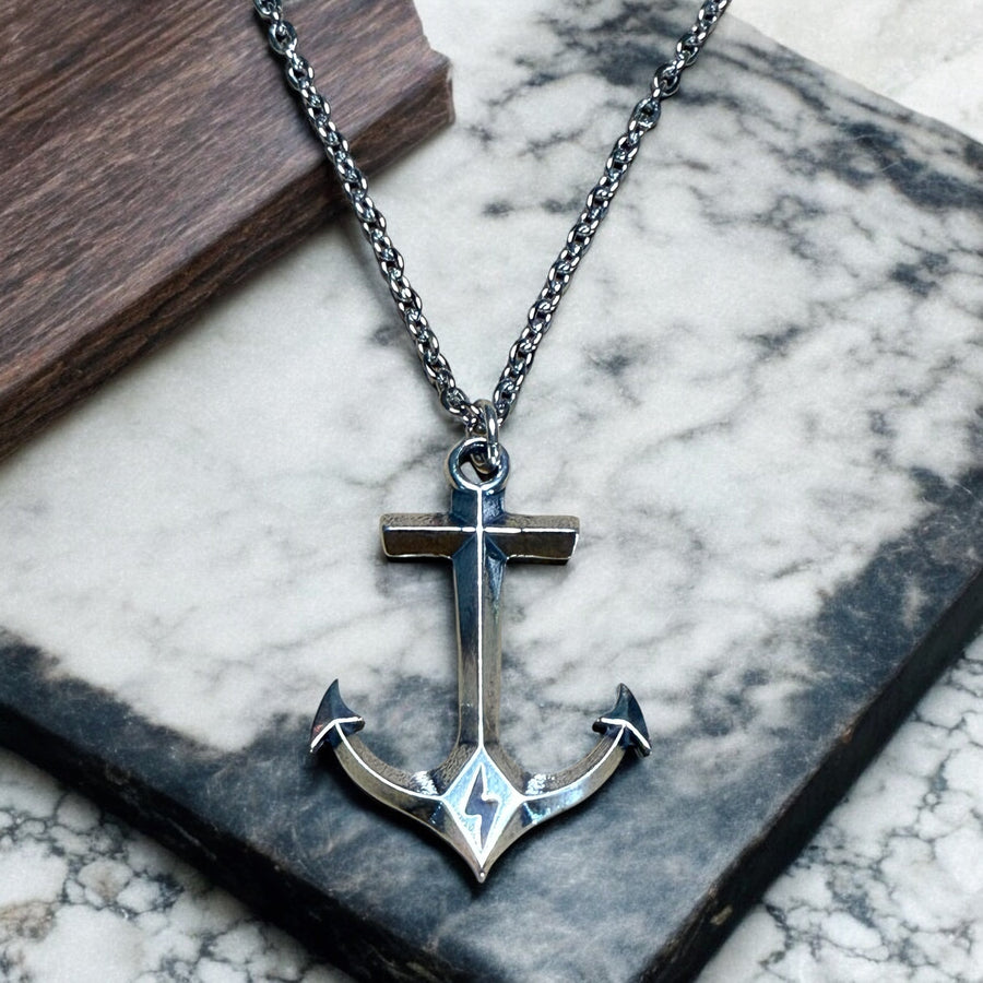 Anchor pendant and chain against pale stone