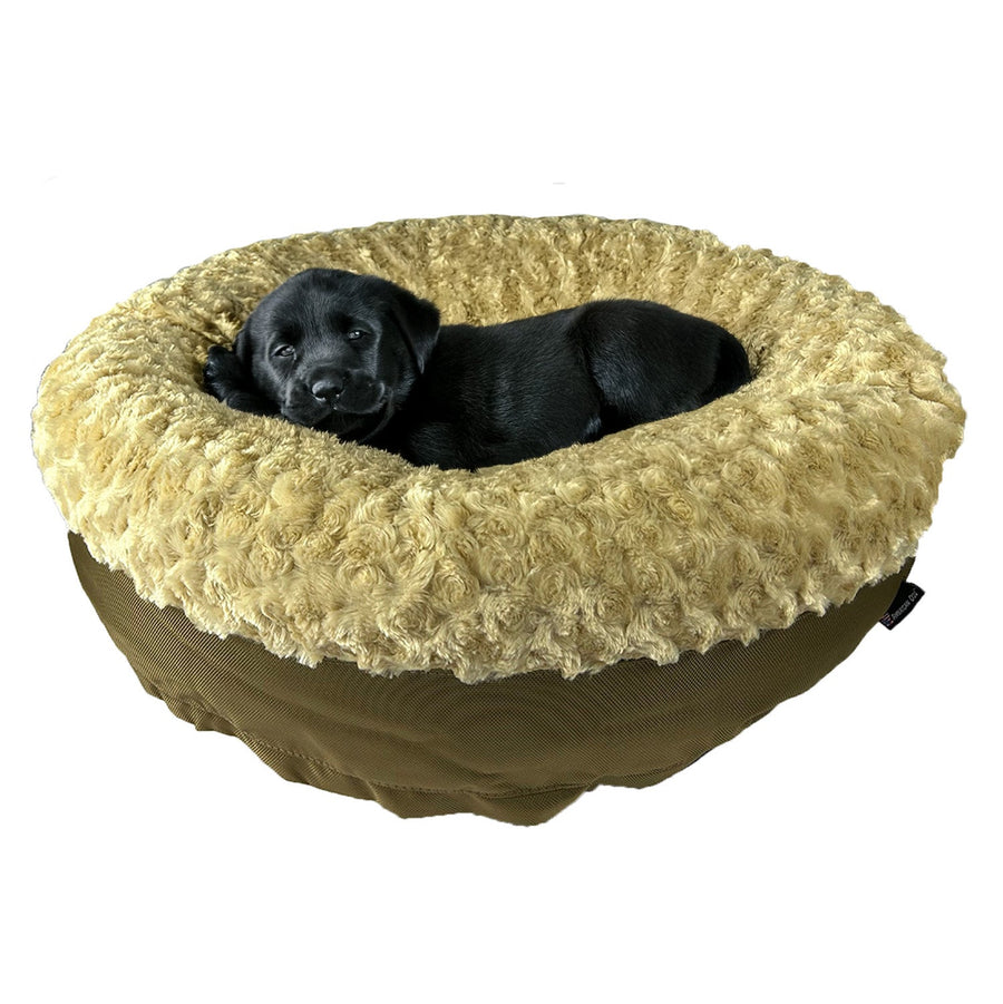 Black puppy resting in a camel Furvana round bolster dog bed