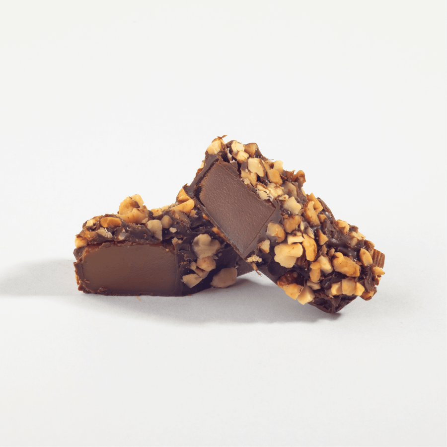Chocolate-covered caramel almond sticks with a chopped almond coating