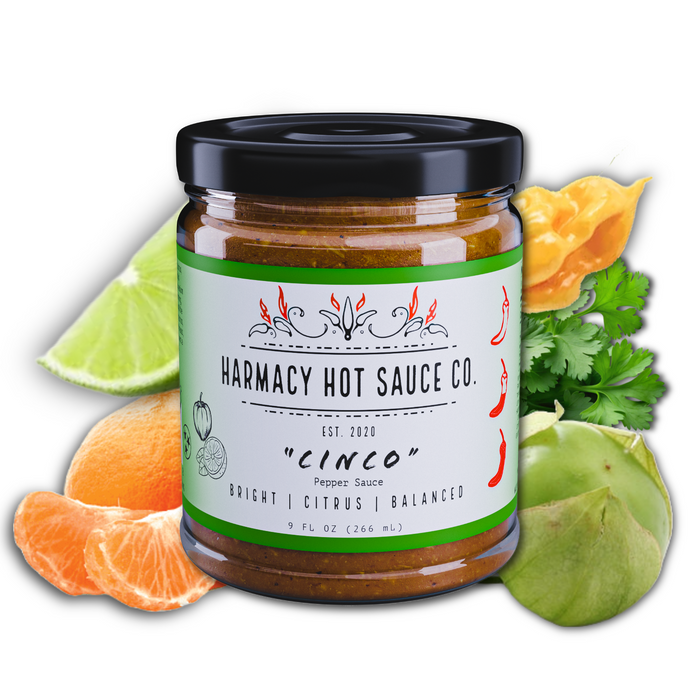 Cinco tomatillo and citrus hot sauce jar with citrus and peppers