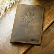Leather journal resting open on a wooden table.
