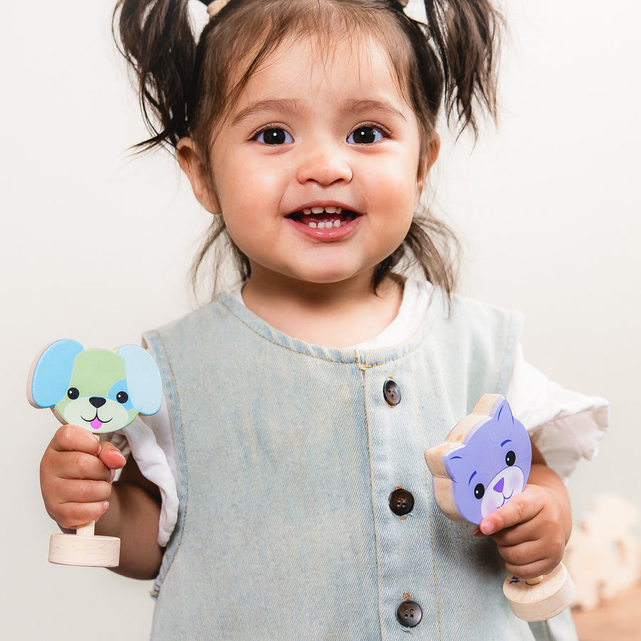 Child playing with dog and cat wooden baby rattles