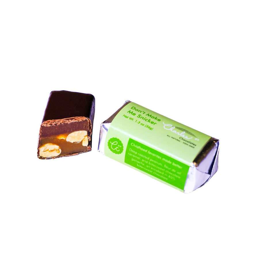 Peanut caramel and ganache bar displayed beside its opened green wrapper
