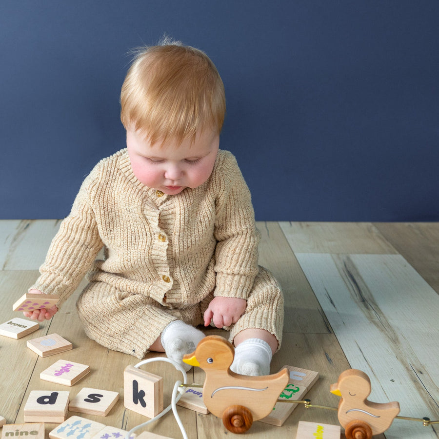 Baby exploring a linked wooden animal pull toy