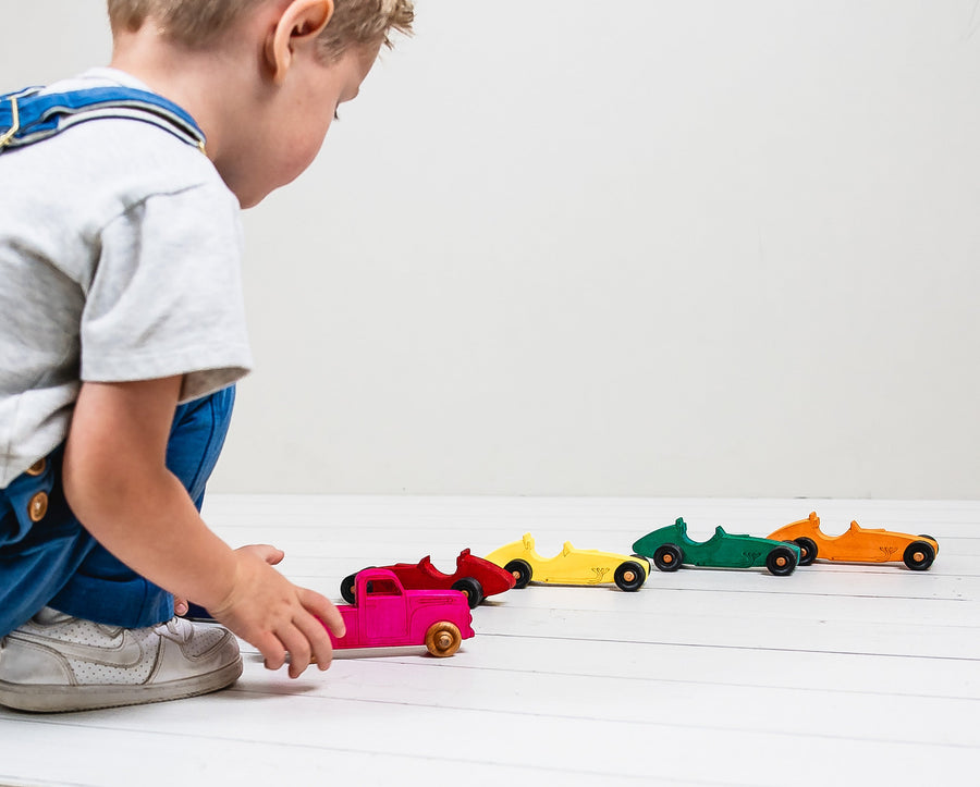 Colorful wooden Indy-style toy cars arranged for racing play