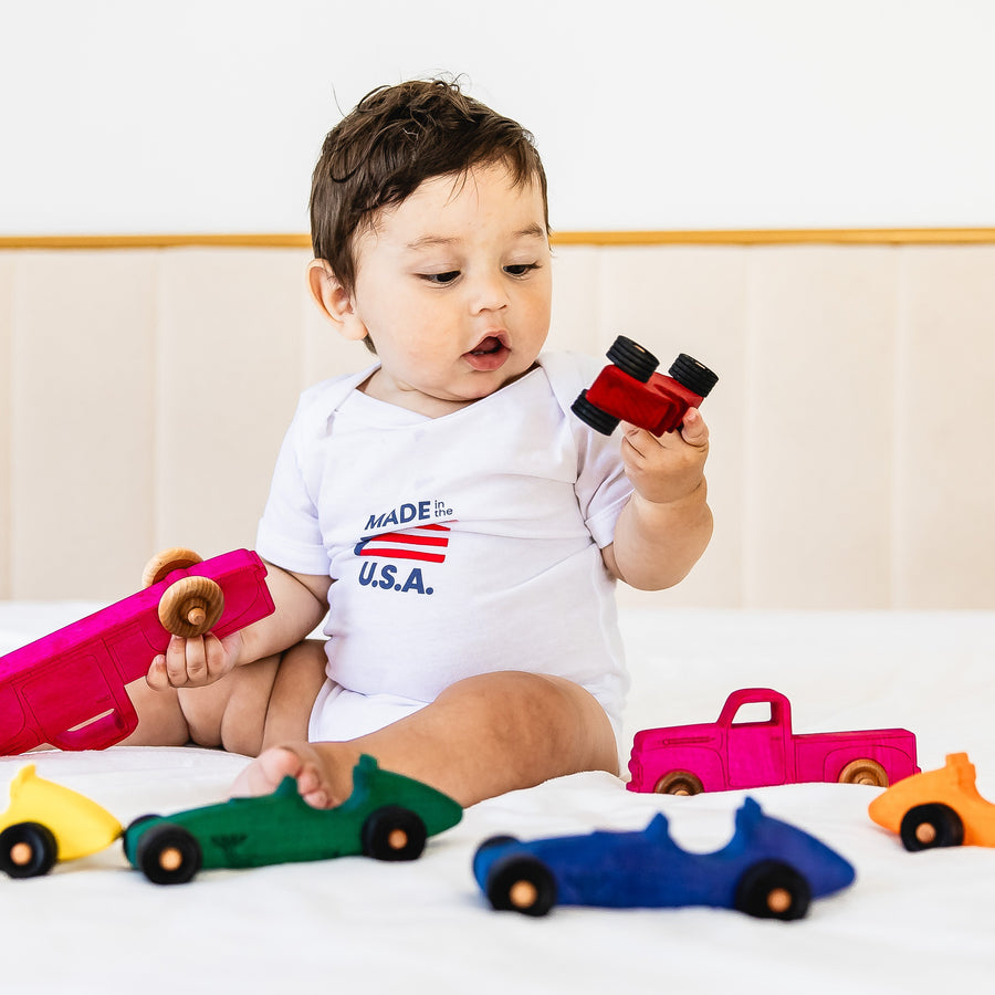 Colorful wooden Indy-style toy cars arranged for racing play