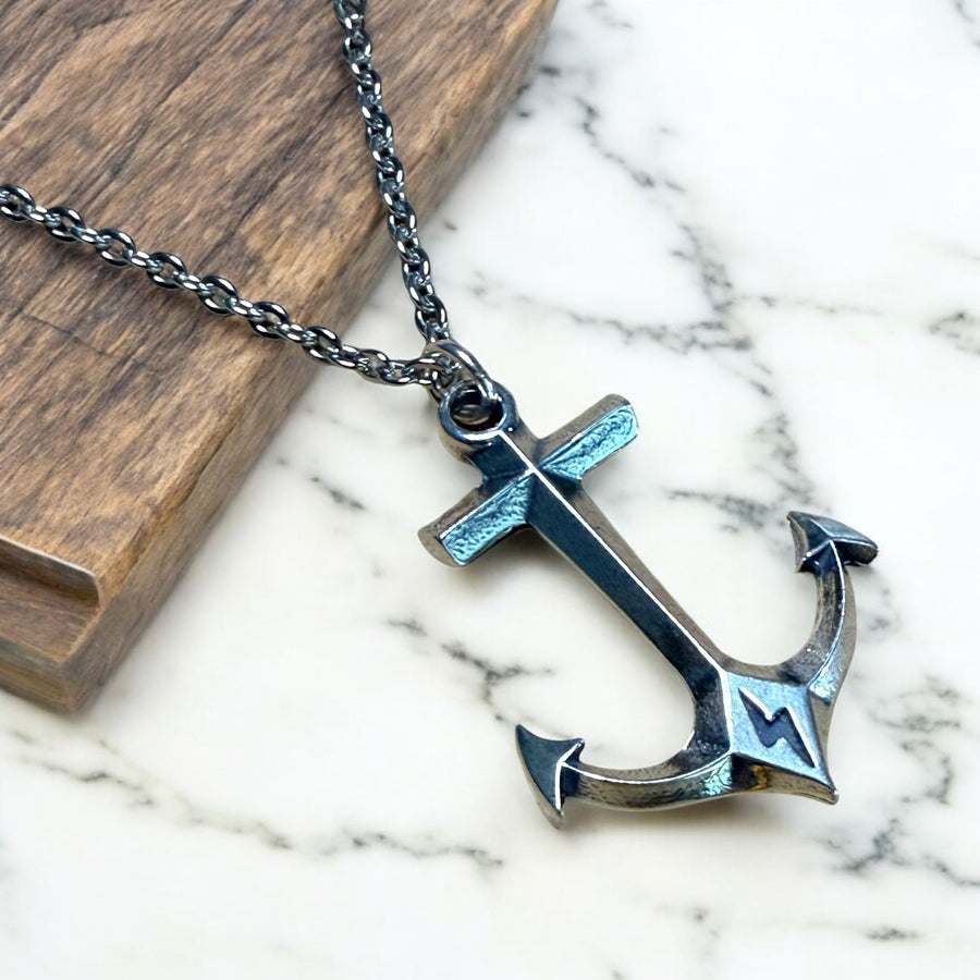 Hold Fast Anchor pendant and chain on pale stone and wood