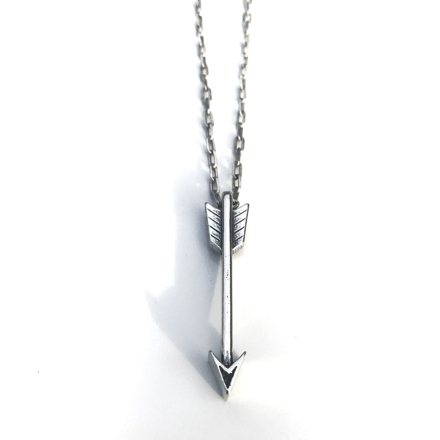 Arrow pendant hanging vertically against white