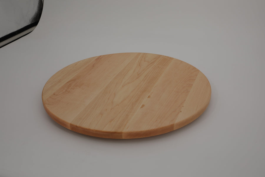 Round maple cutting board photographed at a low angle