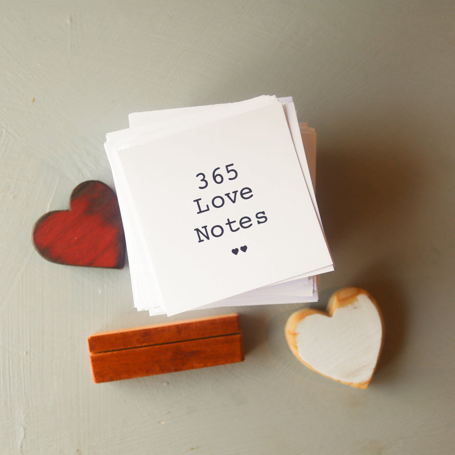 365 Love Notes title card in a wooden stand beside two small hearts.