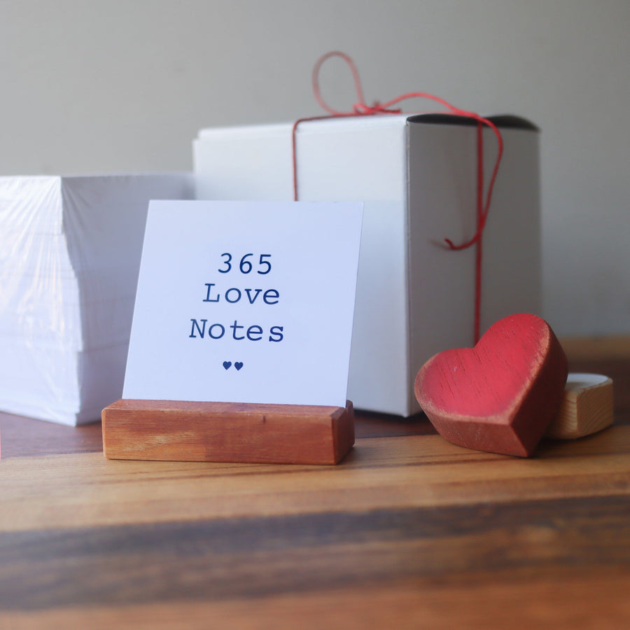 Love Notes cards displayed with a wooden stand, gift box, and heart.