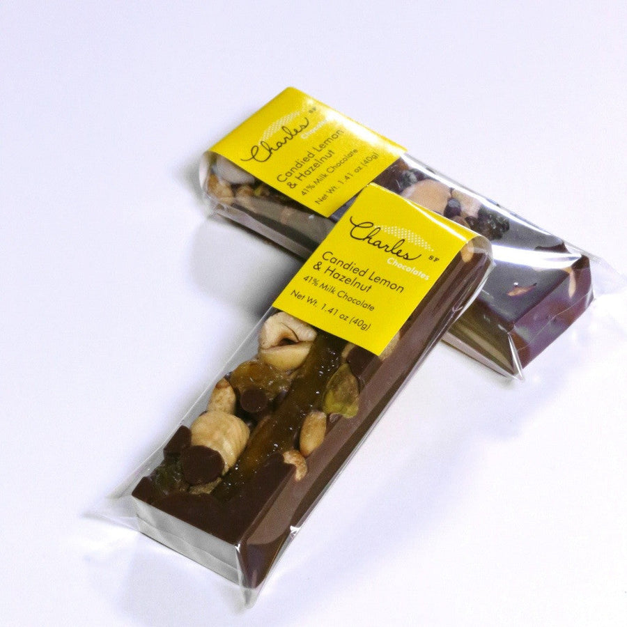 Milk chocolate lemon and hazelnut mendiant bar with opened packaging