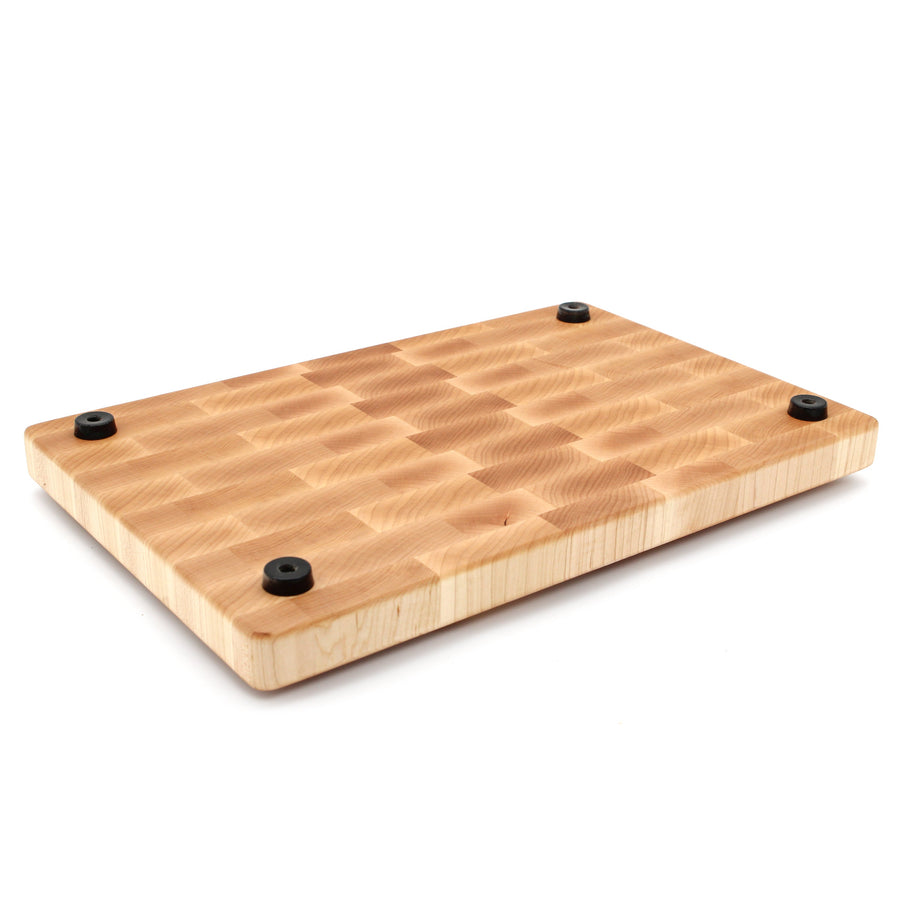 Underside of a maple end-grain board with four rubber feet