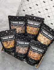 Manly Mixed Nuts Box featuring six assorted snack packs in black and white packaging