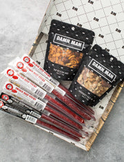 Assorted beef sticks and nuts in a Damn Man Nuts & Beef Box for high-protein snacking