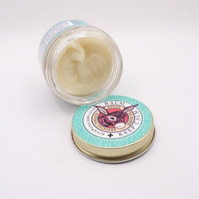Open Calm Balm jar showing the balm texture beside its lid