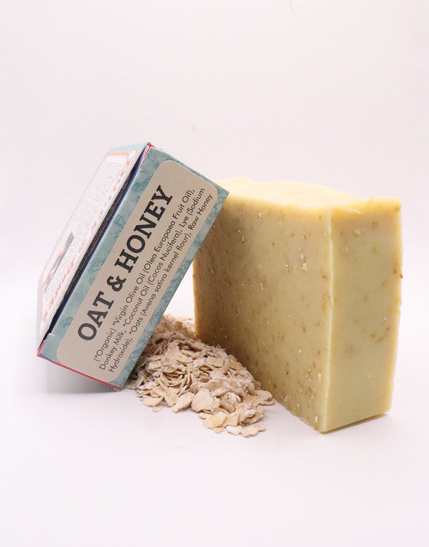 Oat and honey soap beside the ingredient end of its box and loose oats