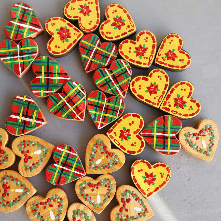Hand-painted wooden hearts with colorful Christmas patterns.