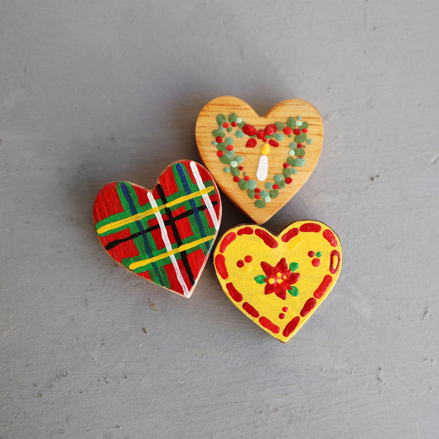 Hand-painted wooden hearts with colorful Christmas patterns.