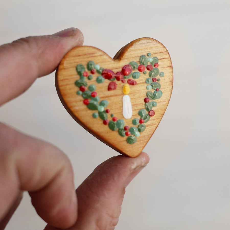 Hand-painted wooden hearts with colorful Christmas patterns.