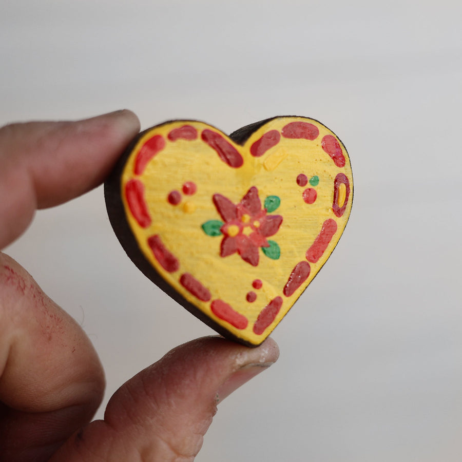 Hand-painted wooden hearts with colorful Christmas patterns.