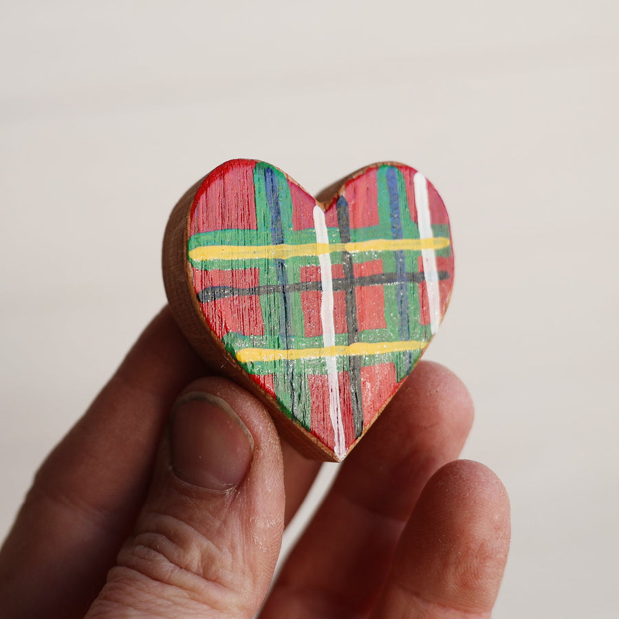 Hand-painted wooden hearts with colorful Christmas patterns.