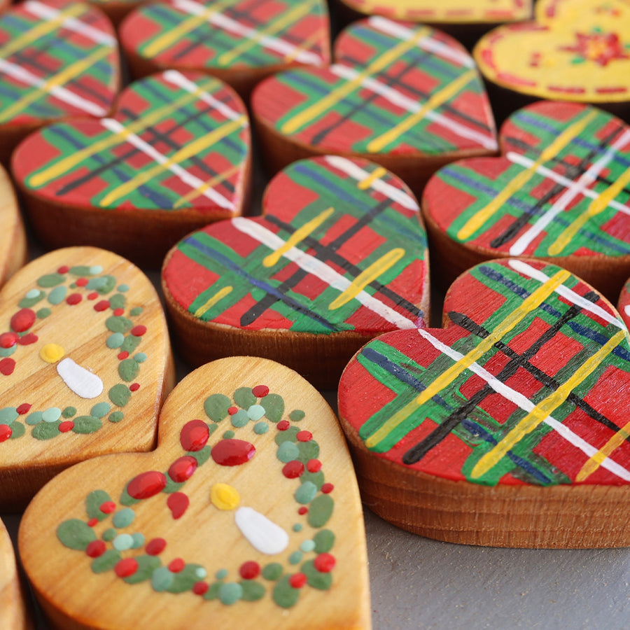Hand-painted wooden hearts with colorful Christmas patterns.