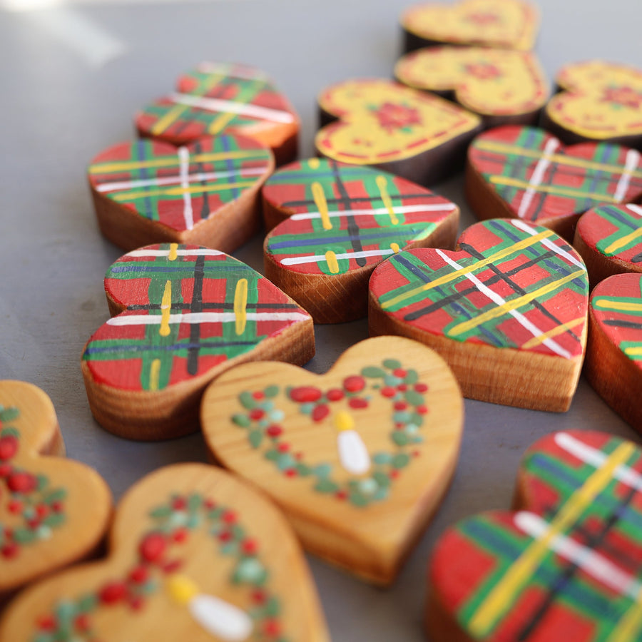 Hand-painted wooden hearts with colorful Christmas patterns.