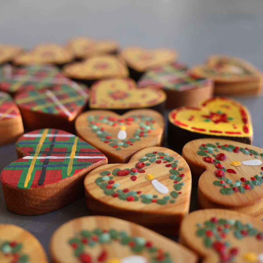 Hand-painted wooden hearts with colorful Christmas patterns.