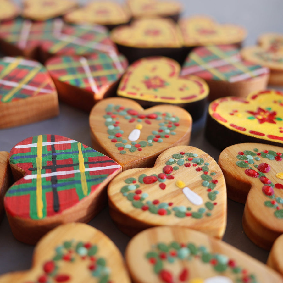 Hand-painted wooden hearts with colorful Christmas patterns.