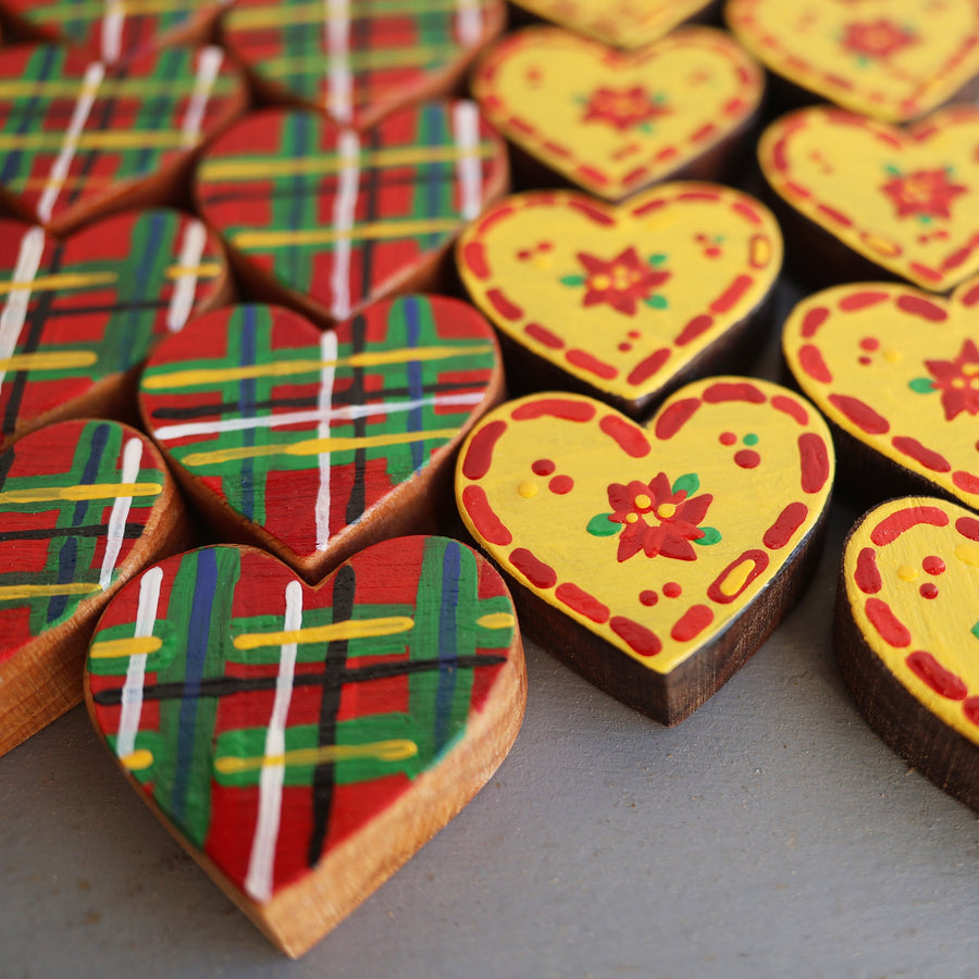 Hand-painted wooden hearts with colorful Christmas patterns.